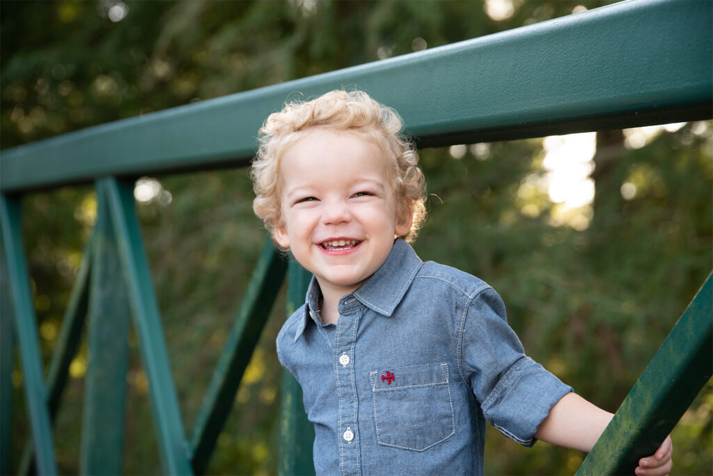 Photo of 2 year old blonde curly haired boy on bridge in Orlando Florida