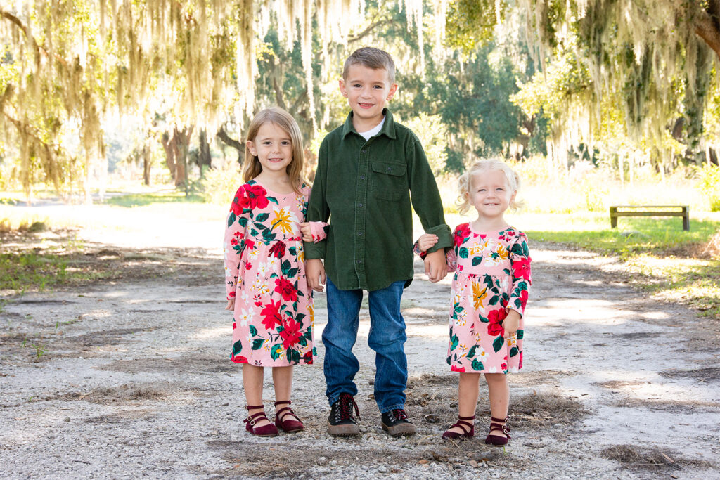 5 year old, 3 year old and 1 year old at Johns Lake Park in Winter Garden. Girls in flower dresses and boy in green corduroy shirt.