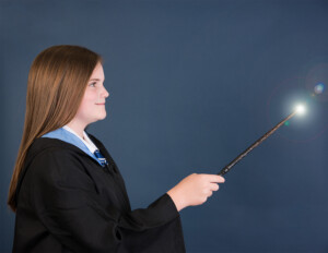 Redhead preteen girl win Harry Potter robes with want casting a spell in Winter Garden Florida