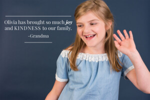 Blonde preteen girl with brown eyes in blue dress, smiling in Winter Garden, Florida. Quote "Olivia has brought so much joy and kindness to our family - Grandma"